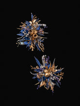 The Blue and Gold Baroque Castle Wedding Flower Rings by CAMELLIA display intricate floral arrangements with metallic textures and diverse plant shapes, set against a black background, embodying the elegance of preserved flowers.